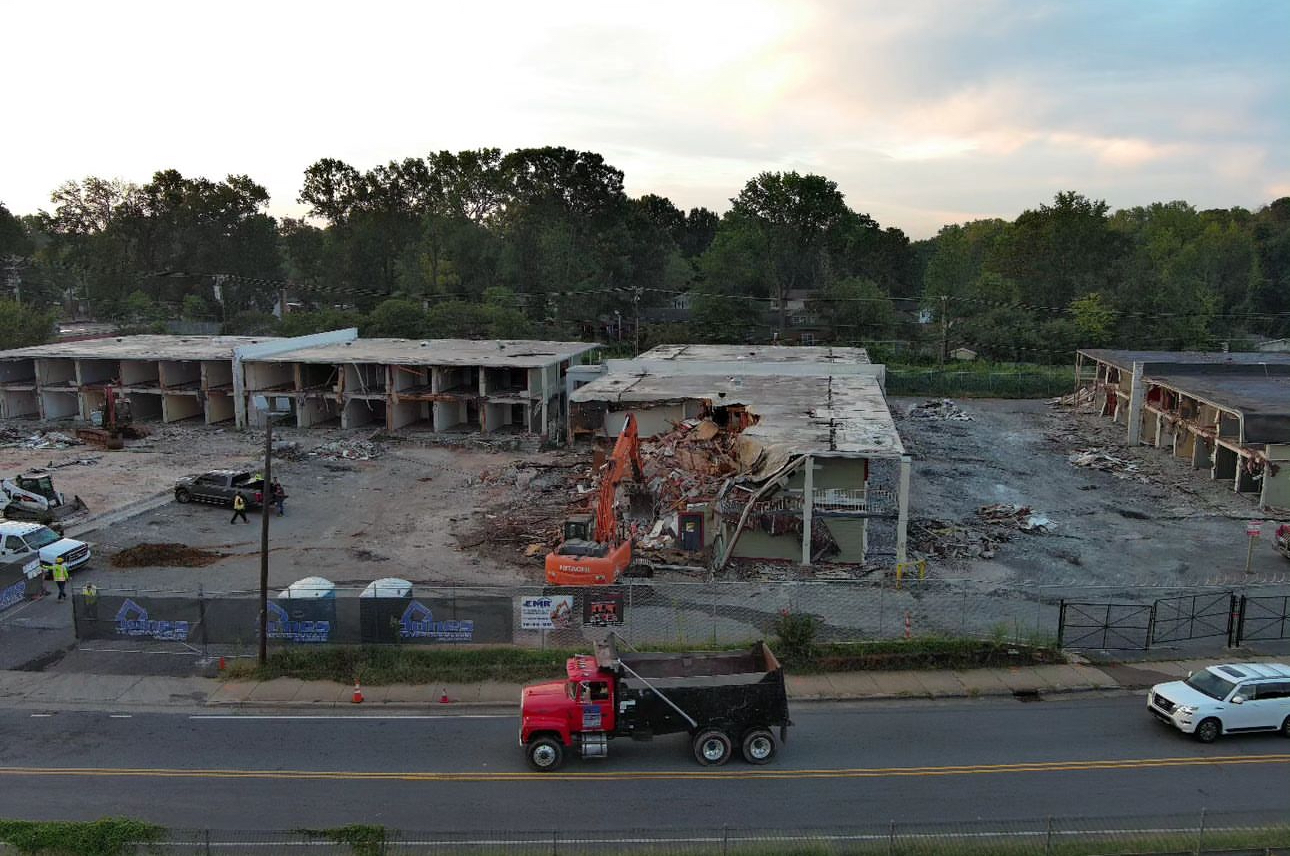 Excavator actively demolishing the Reagan Drive hotel during the City of Charlotte demolition project.
