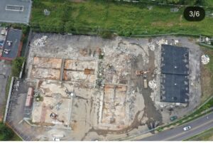 Aerial drone view of a commercial demolition site showing multiple demolished buildings, concrete slab removal, heavy excavators, demolition debris, and site clearing operations performed by JCE, Inc. for a redevelopment project in Charlotte, North Carolina.