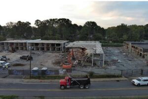 Excavator actively demolishing the Reagan Drive hotel during the City of Charlotte demolition project.