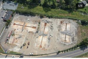Aerial view showing concrete foundation removal at the Reagan Drive hotel demolition site.